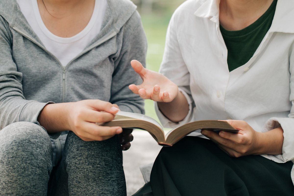 Jemand erklärt einer anderen Person die Bibel